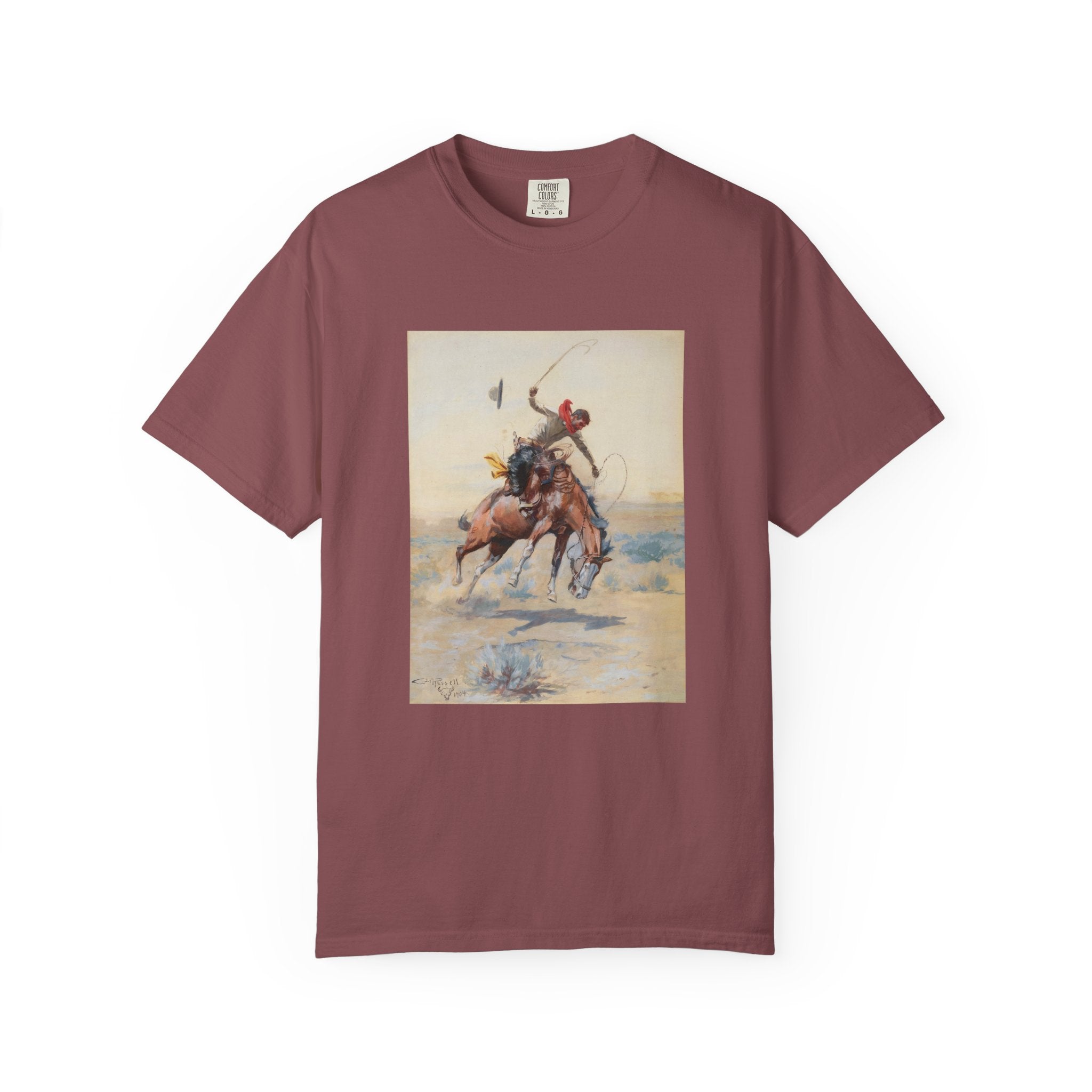 Maroon T-shirt featuring Charles Marion Russell’s The Bucker, showing a cowboy riding a bucking horse in a Western landscape.