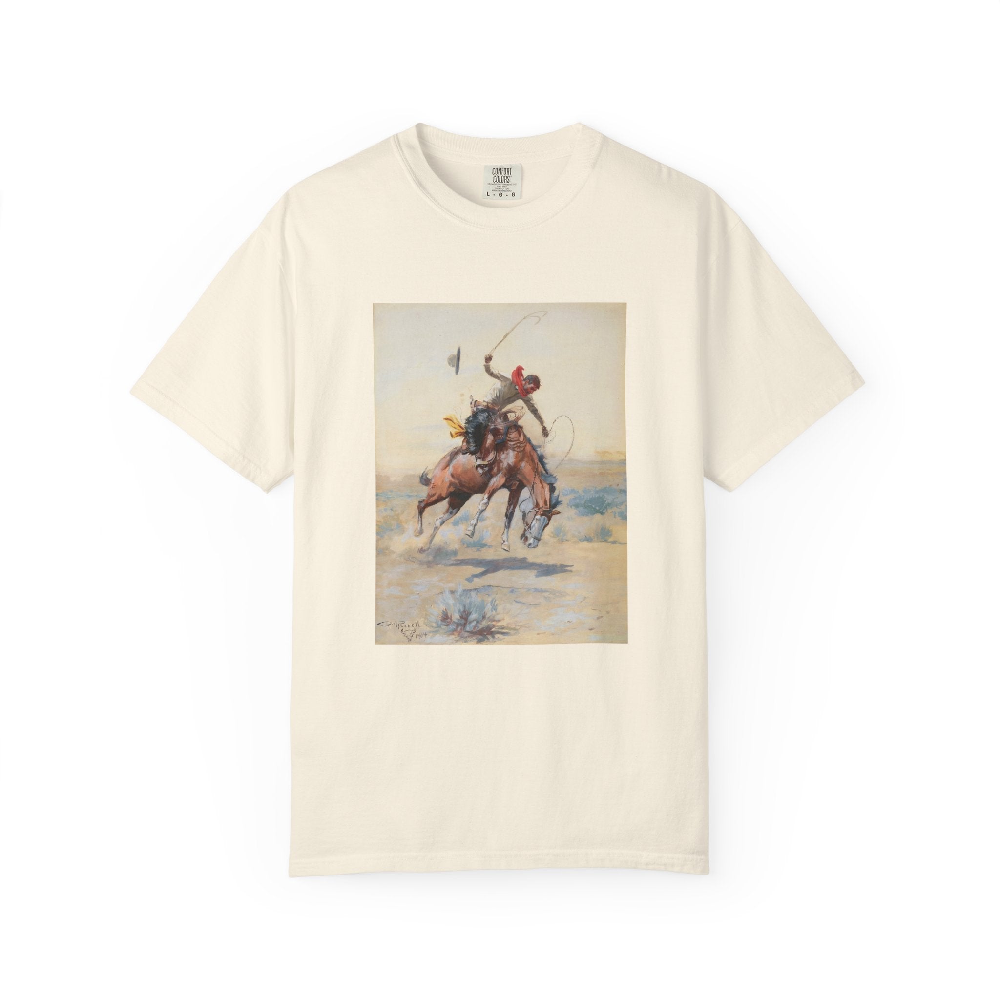 Beige T-shirt featuring Charles Marion Russell’s The Bucker, showing a cowboy riding a bucking horse in a Western landscape.